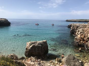 Scenic view of rocks in sea against sky