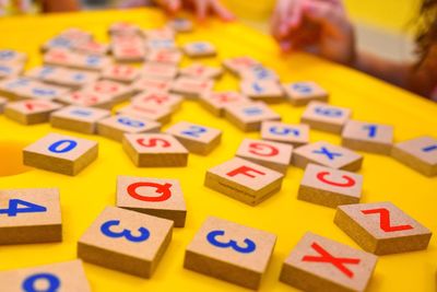 Alphabets and numbers on wooden blocks at table