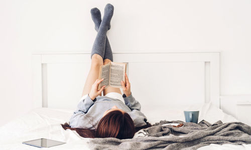 Woman lying on bed at home
