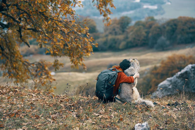 Man sitting on field during autumn