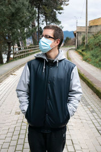 Full length of young man standing on footpath