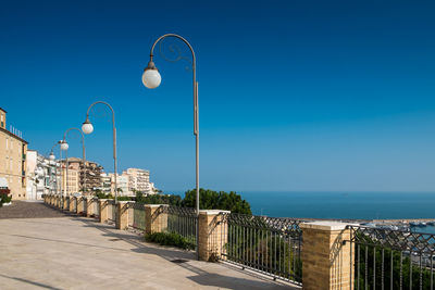 Lighting equipment by railing against clear blue sky