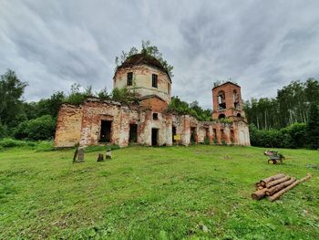 Old ruins of building on field against sky