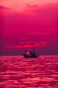 Silhouette of fishing boat on sea against sky during sunset