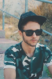 Young man wearing sunglasses sitting on steps