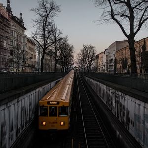 Railroad tracks amidst bare trees against sky