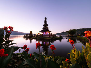 Pura ulu danau temple in lake against clear sky during sunset