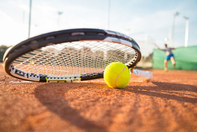 Close-up of tennis ball and racket on field 