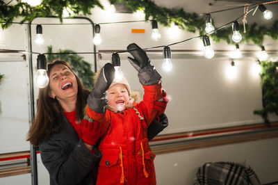 Smiling mother and son standing against motor home