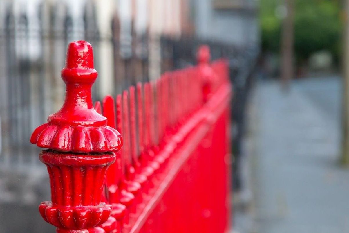 red, focus on foreground, architecture, built structure, day, close-up, city, no people, in a row, street, security, outdoors, safety, protection, metal, footpath, fire hydrant, barrier, boundary, single object