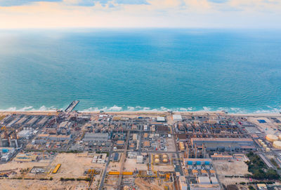 High angle view of buildings by sea against sky