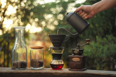 Dripping coffee set in the morning sunlight on outdoor wooden table
