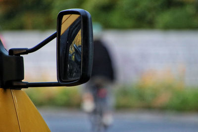 Close up of side-view mirror in front  of bicycle