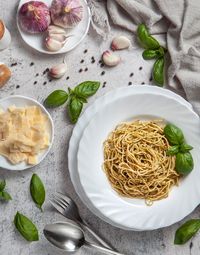 High angle view of pasta with pesto sauce and ingredients on table