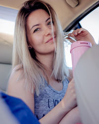 Portrait of young woman sitting in car