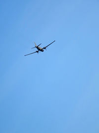 Low angle view of airplane against clear blue sky