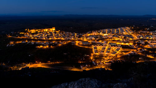 Illuminated cityscape against sky at dusk