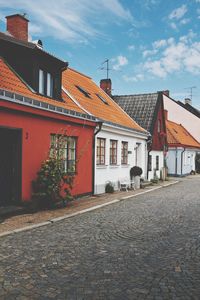 Houses by street against sky in city