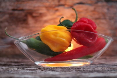 Close-up of chili peppers and bell peppers in bowl on table