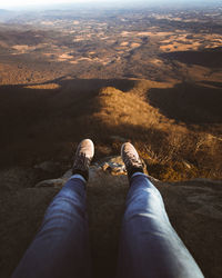 Low section of man standing on landscape against sky