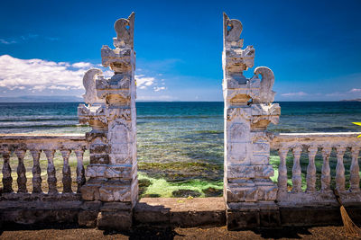 Wooden posts on beach against sky