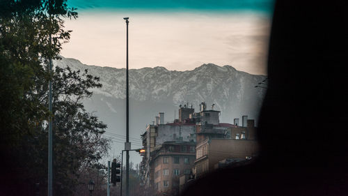 Buildings in city against cloudy sky