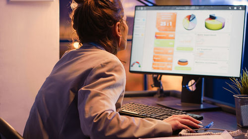 Midsection of woman using laptop at office