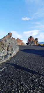 Rock formations on road against sky