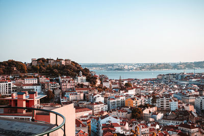 High angle view of townscape by sea against clear sky