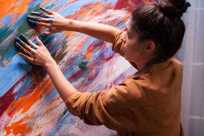 Rear view of woman painting at home