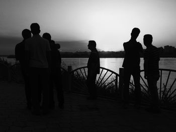 Silhouette man in sea at sunset