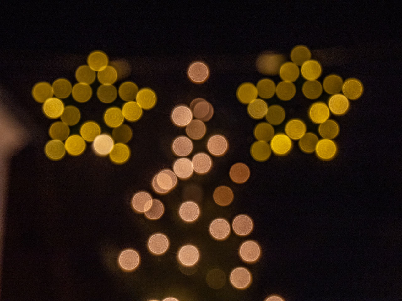 DEFOCUSED IMAGE OF ILLUMINATED CHRISTMAS LIGHTS AT NIGHT