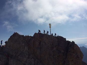 Low angle view of rocks on cliff against sky