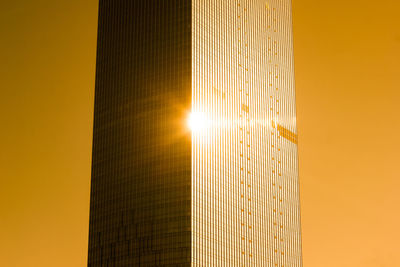 Low angle view of sun setting against yellow sky