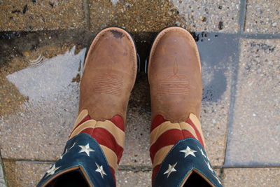 Low section of man standing on wet street