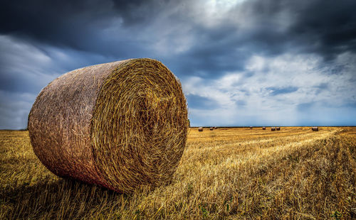 Hay bales on field against sky
