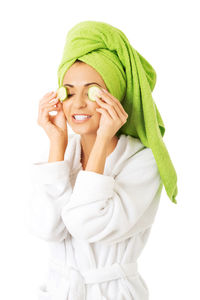 Close-up of woman in bathrobe standing against white background