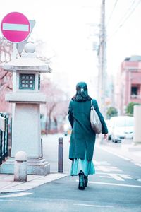 Rear view of man walking on road