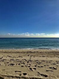 Scenic view of beach against blue sky