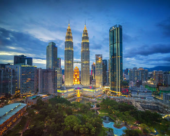 Illuminated buildings in city against sky