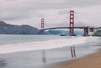 Suspension bridge over sea against sky