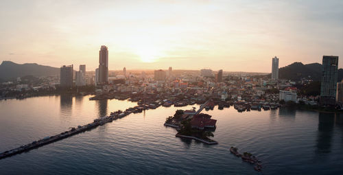 Aerial view of buildings in city against sky during sunset