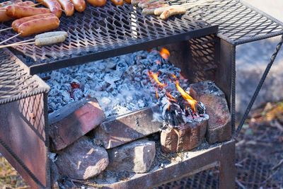 Fire in a rusty vintage grill outdoor with blurred background.