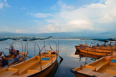 Boats moored in sea against sky