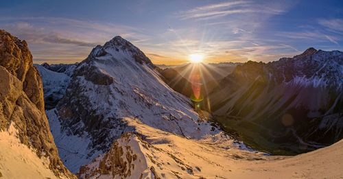Panoramic view of snowcapped mountains against sky during sunset
