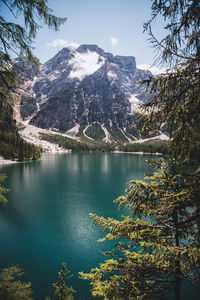 Scenic view of lake by snowcapped mountains against sky