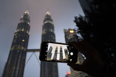 Low angle view of illuminated tower against sky in city