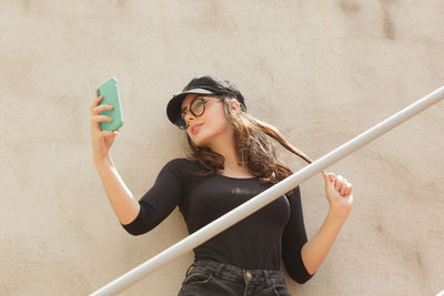 Happy woman taking selfie through smart phone