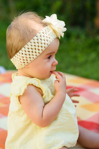 Cute girl in yellow baby clothing at back yard