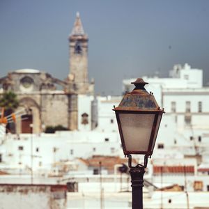 Street light on old building against sky